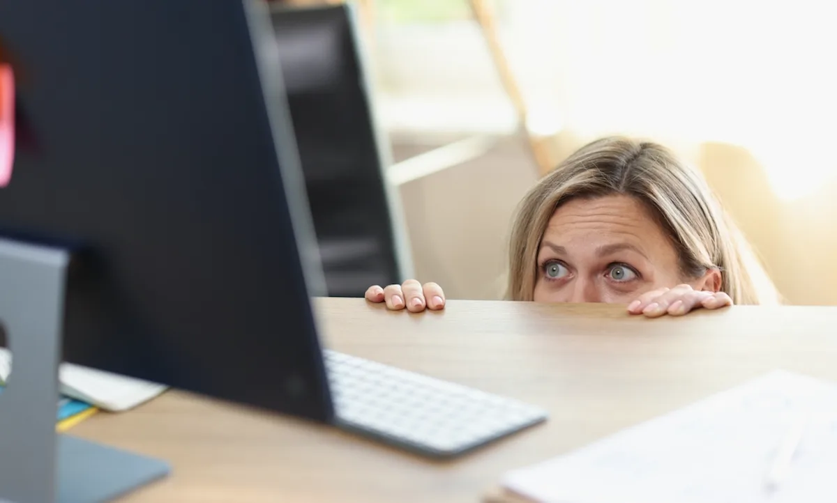 El valiente, la grasa y lo extraño en fintech ai woman cowering below computer